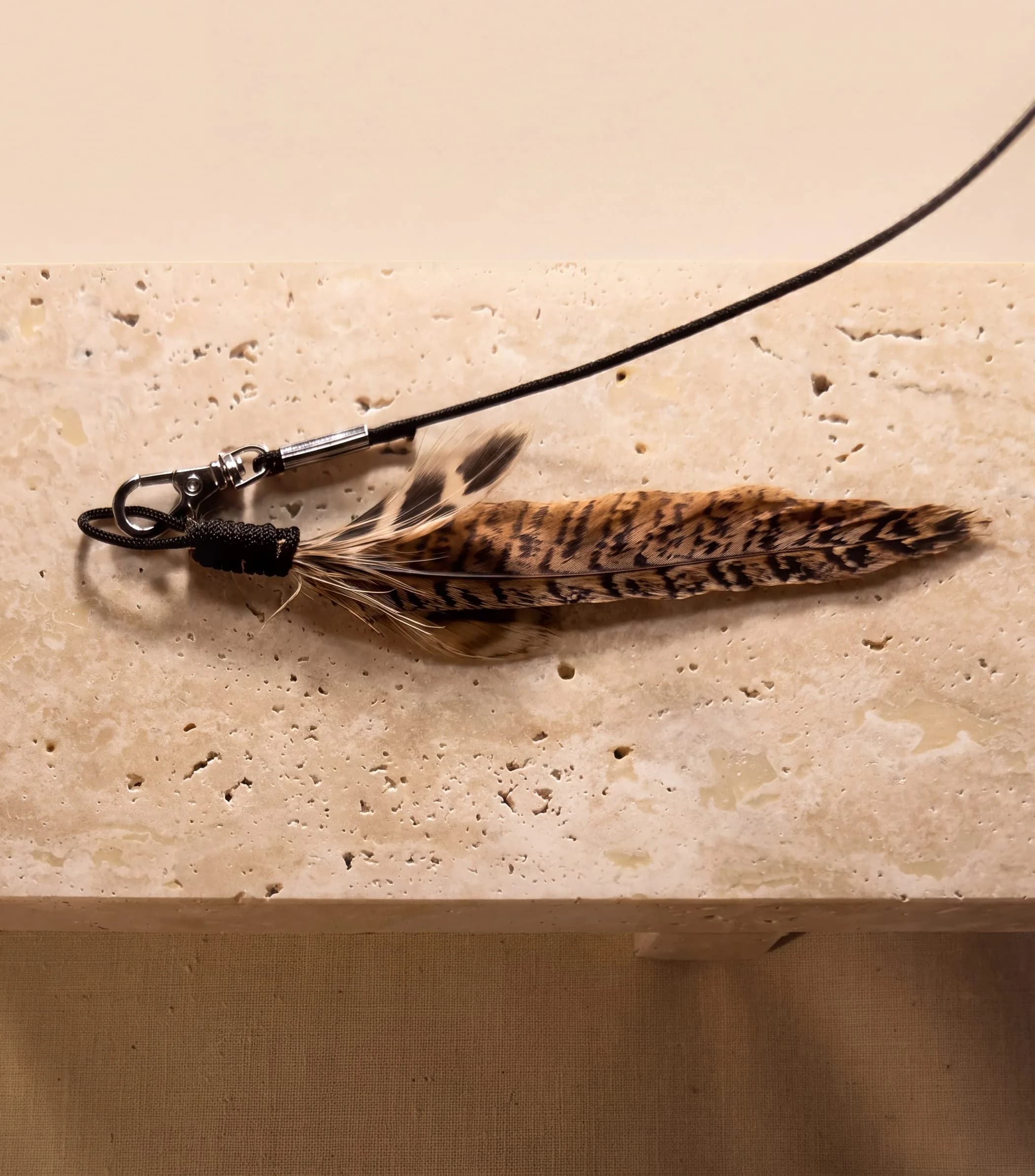 The Wren - hand-tied pheasant on a Dyneema cord - laid on stone